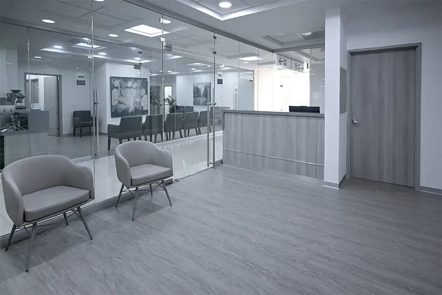 Sala de espera con sillones y mamparas de vidrio